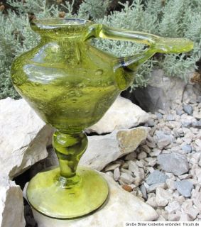eine alte Öllampe aus grünem Glas mit eingeschlossenen Blasen.